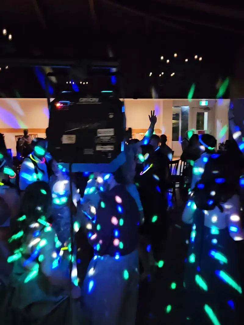 Piste de danse pleine sous des lumières bleues et vertes lors d'un mariage