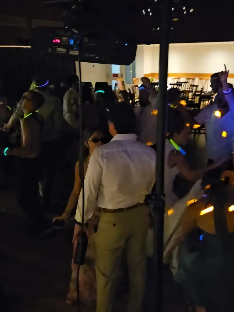Invités avec des bâtons lumineux sur la piste de danse